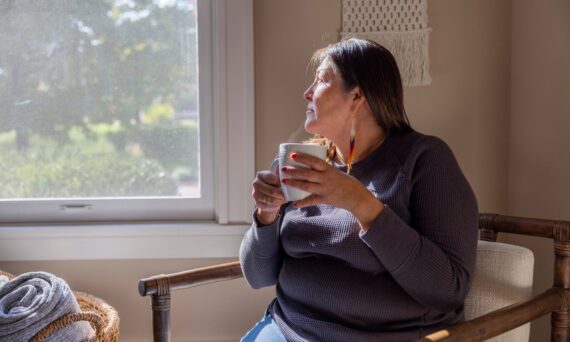 Native American woman looking out a window